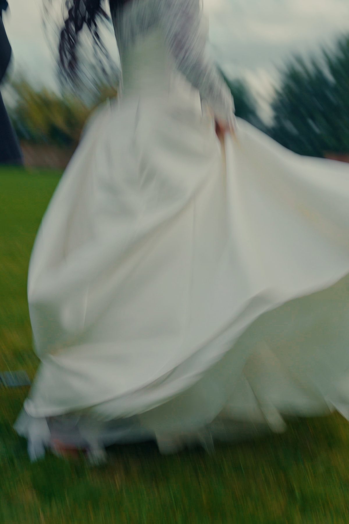 A wedding dress swirling across the grass
